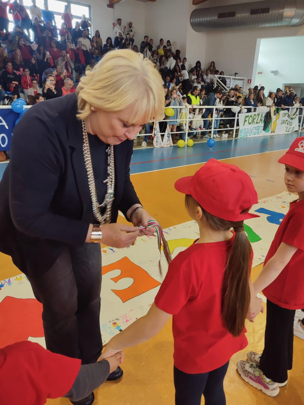 La presidente dalla Fism Treviso Simonetta Rubinato premia una bamabina partecipante alle Miniolimpiadi